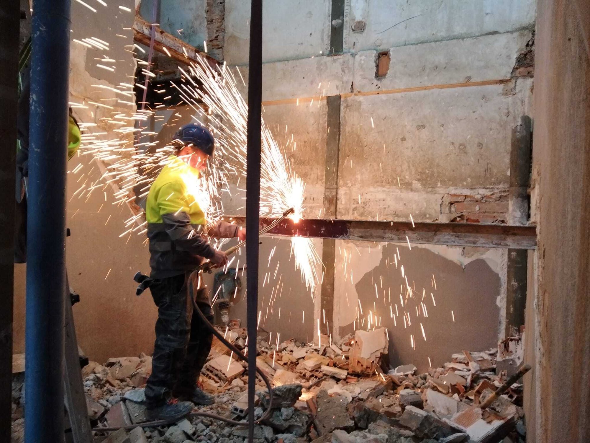 imagen de un operario cortando metal en una demolición imagen de un operario cortando metal en una demolición